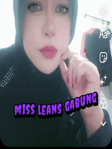 a woman wearing a hijab with the words miss leans gabung written on her face