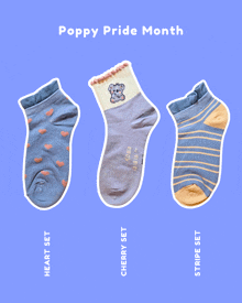 three pairs of socks with the words poppy pride month written on the top