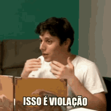 a man sitting at a table with a sign that says " isso e violacao "