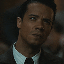 a close up of a man 's face with a suit and tie