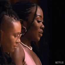 two women are standing next to each other in a dark room .
