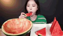 a young woman is eating a slice of watermelon