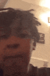 a close up of a person 's face with dreadlocks on their head .