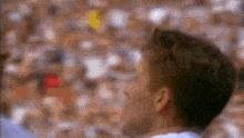 a blurry picture of a man 's face with a crowd in the background