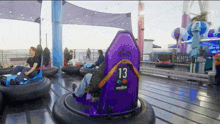 a person riding a bumper car with the number 13 on it