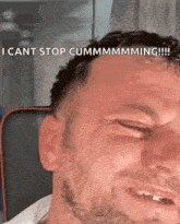 a man with a beard is making a funny face while sitting in a chair .