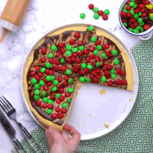 a pizza with a slice taken out of it and m & m 's on top