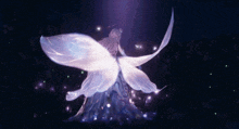 a woman in a blue dress with white wings is standing in a dark room