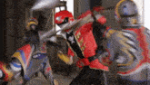 a group of power rangers are fighting each other in a room with swords .