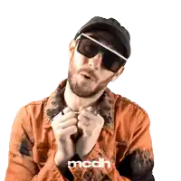 a man wearing sunglasses and a hat has the word mcdh written on his shirt