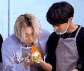 a man in an apron is eating a piece of food with korean writing on it