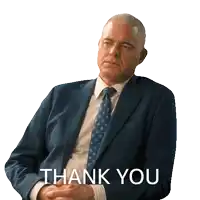 a man in a suit and tie says thank you with his hands folded
