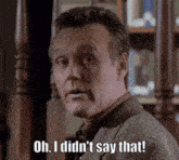 a man says oh i did n't say that in front of a bookshelf