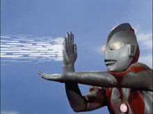 a man in a superhero costume is holding up his hands in the air