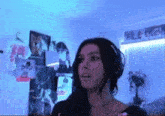 a woman wearing headphones is standing in a room with blue lights on the walls .