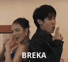 a man and a woman are standing back to back with the word breka on the bottom right