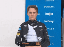 a man standing in front of a blue wall that says duracell