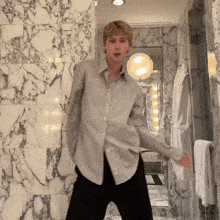 a man is dancing in a bathroom with marble tiles
