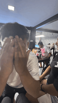 a person covering their face with their hands in a room