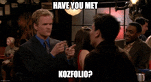 a man in a suit and tie is pointing at another man with the caption have you met kozfolio ?