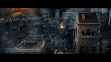 an aerial view of a burning city with a few buildings in the foreground