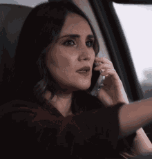 a woman talking on a cell phone in a car