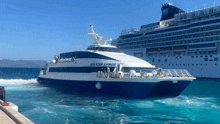 a large cruise ship is docked next to a smaller boat in the water .