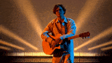 a man is playing an acoustic guitar in front of a crowd