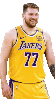 a man wearing a lakers jersey number 77 smiles