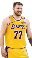 a man wearing a lakers jersey number 77 smiles