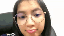 a woman wearing glasses is making a funny face .