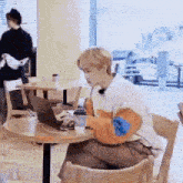 a man is sitting at a table with a laptop computer .