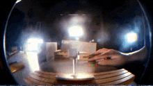 a person 's hand reaches for a glass of wine on a table