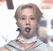 a close up of a person wearing a choker and a microphone in their mouth .