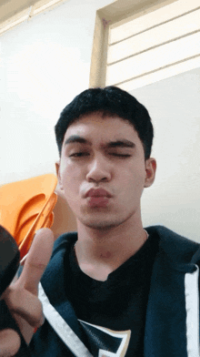 a young man making a funny face with his fingers in his mouth