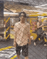 a man is behind a chain link fence in a gym .
