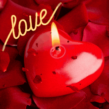 a heart shaped candle with the word love written above it
