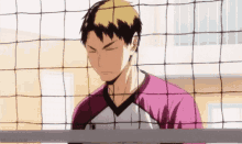 a man in a pink shirt is standing behind a volleyball net with his eyes closed .