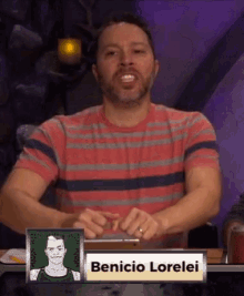 a man in a striped shirt is sitting at a table with a sign that says benicio lorelei .