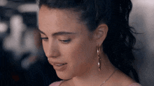 a woman wearing hoop earrings and a necklace