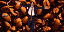 a man in a suit and tie is surrounded by coffee beans with the hashtag gigigx