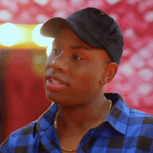 a man wearing a hat and a plaid shirt