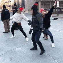 a group of people standing on a sidewalk with one wearing a red hat that says chicago