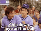 two baseball players are standing next to each other and talking to each other .