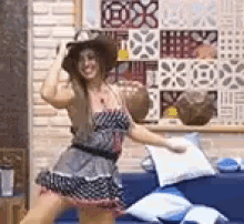 a woman wearing a hat and a dress is dancing in a living room .