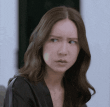a woman with long hair is making a surprised face