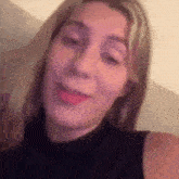 a close up of a woman 's face with her mouth open and a black shirt on .