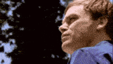 a man in a blue shirt is looking to the side