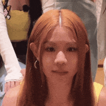 a close up of a woman 's face with long red hair and earrings