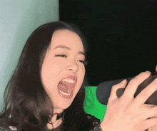 a woman with her mouth wide open is holding a cell phone